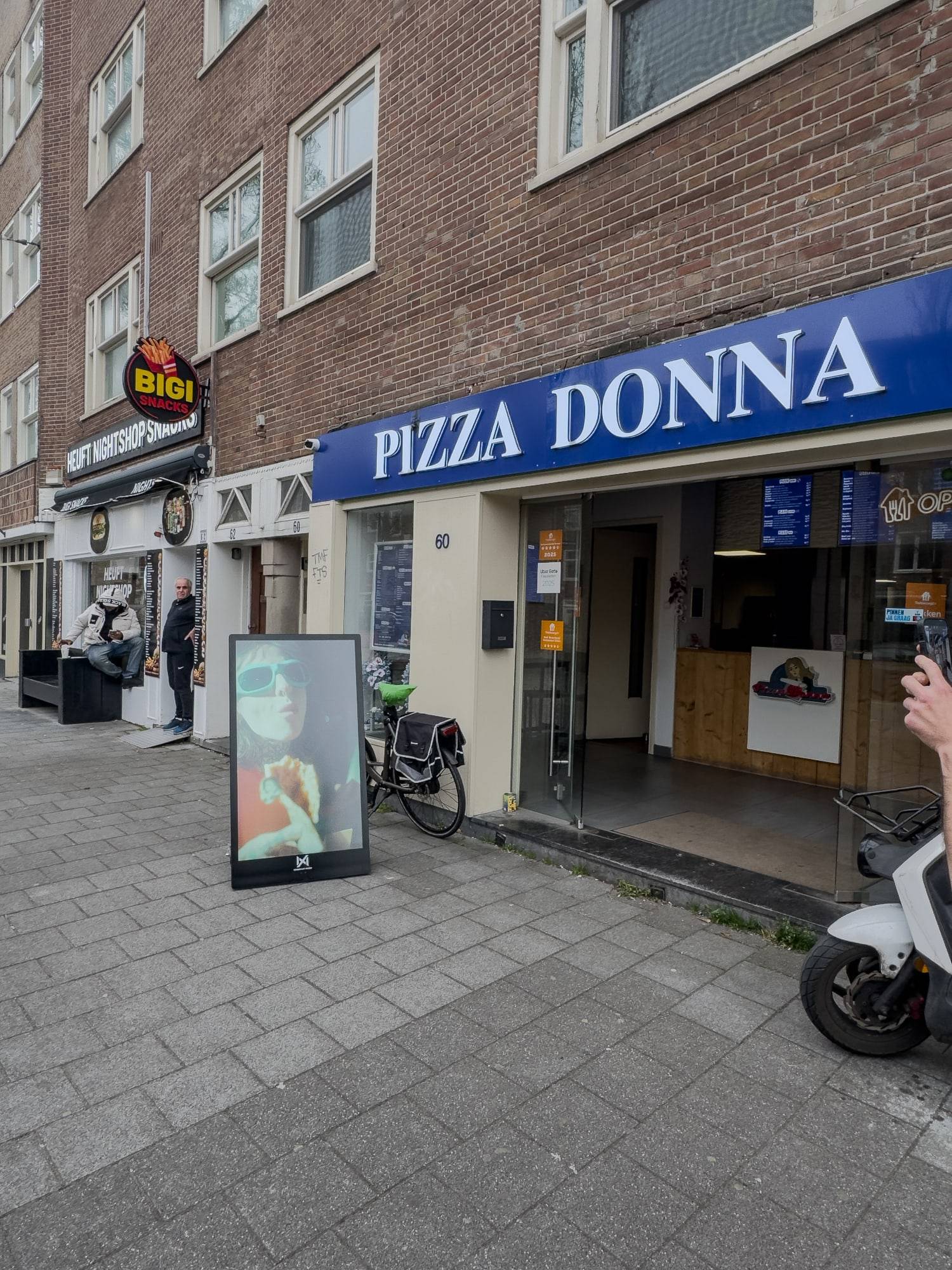 Seabiscuit-buitenscherm voor een pizzeria in een straat met klinkers