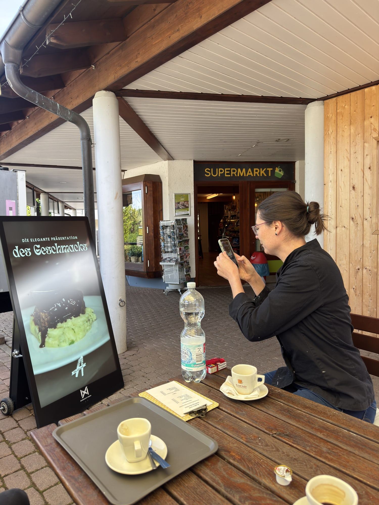 A Seabiscuit display beside café tables while a guest photographs her coffee